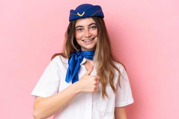 Mulher caucasiana de aeromoça isolada em fundo rosa, dando um polegar para cima gesto