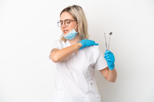 Mulher caucasiana de dentista segurando ferramentas isoladas no fundo branco, sofrendo de dor no ombro por ter feito um esforço