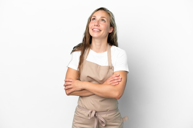 Mulher caucasiana de garçom de restaurante isolada em fundo branco olhando para cima enquanto sorria