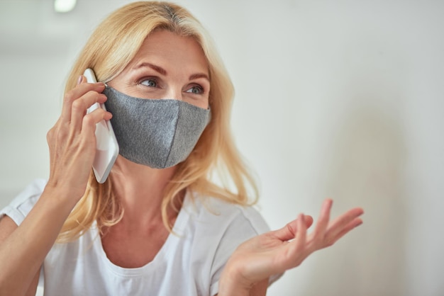 Mulher caucasiana de meia-idade falando ao telefone em casa