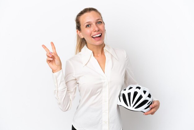Mulher caucasiana de negócios com um capacete de bicicleta isolado no fundo branco sorrindo e mostrando sinal de vitória