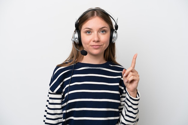 Mulher caucasiana de telemarketing trabalhando com um fone de ouvido isolado no fundo branco, apontando com o dedo indicador uma ótima idéia