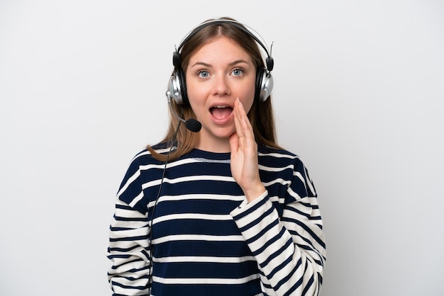 Mulher caucasiana de telemarketing trabalhando com um fone de ouvido isolado no fundo branco com surpresa e expressão facial chocada