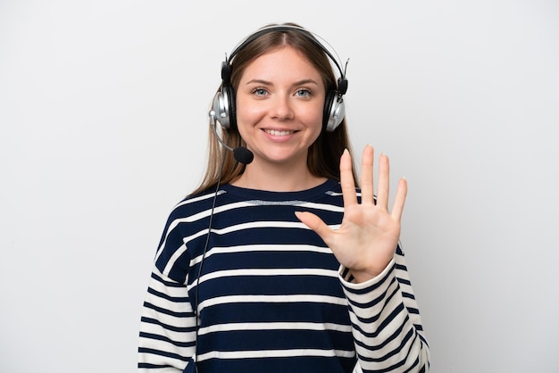 Mulher caucasiana de telemarketing trabalhando com um fone de ouvido isolado no fundo branco contando cinco com os dedos