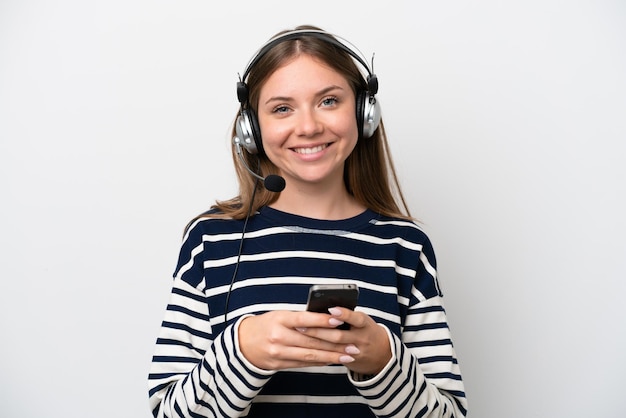 Mulher caucasiana de telemarketing trabalhando com um fone de ouvido isolado no fundo branco enviando uma mensagem com o celular