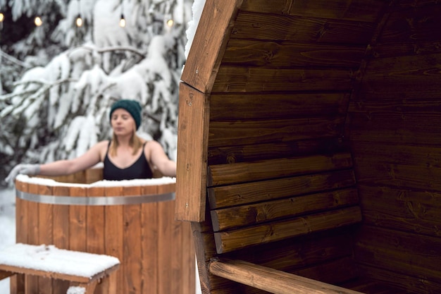 Foto mulher caucasiana durante o banho de inverno em tubo ao ar livre