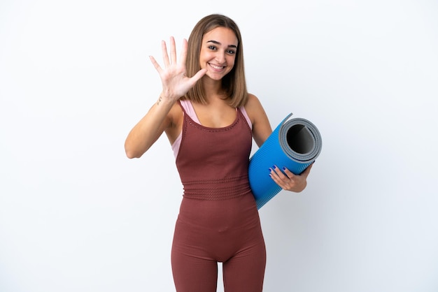 Mulher caucasiana esportiva jovem indo para aulas de ioga isoladas em fundo branco contando cinco com os dedos