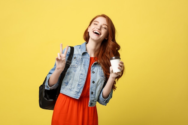 Mulher caucasiana está pulando, em roupa de verão causal no fundo amarelo brilhante