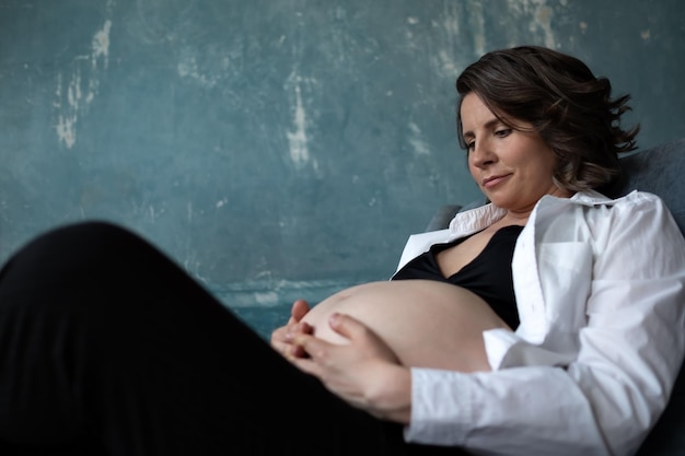 Mulher caucasiana grávida tocando sua barriga. Esperando o bebê