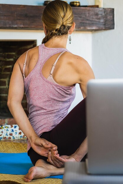 Mulher caucasiana irreconhecível fazendo aulas de ioga on-line, realizando pose de flexibilidade. saúde mental