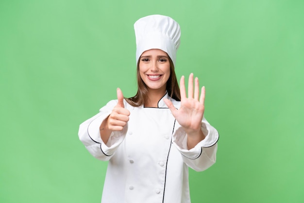 Mulher caucasiana jovem chef sobre fundo isolado, contando seis com os dedos