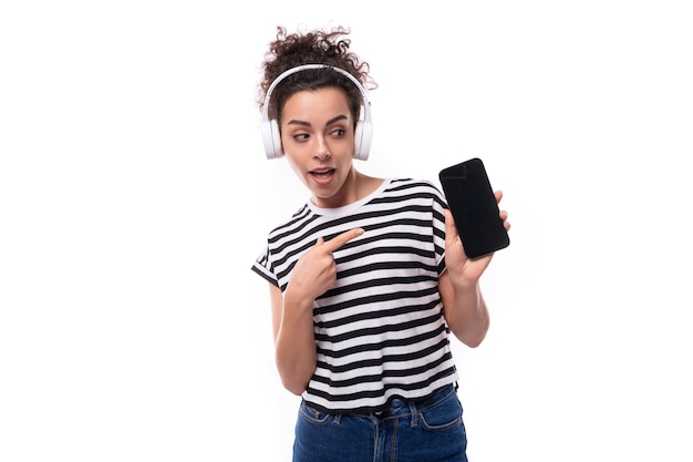 Foto mulher caucasiana jovem e enérgica com cabelos pretos encaracolados vestida com uma camiseta preta e branca listrada