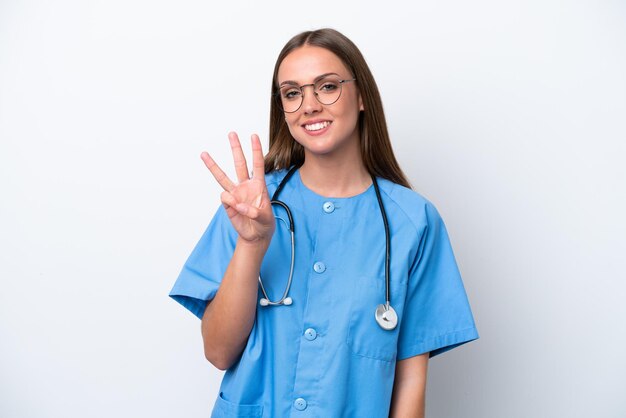 Mulher caucasiana jovem enfermeira isolada em fundo branco feliz e contando três com os dedos