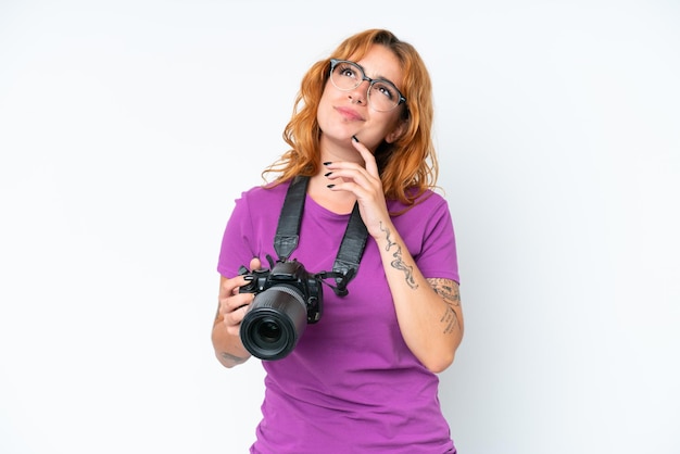 Mulher caucasiana jovem fotógrafo isolada no fundo branco e olhando para cima