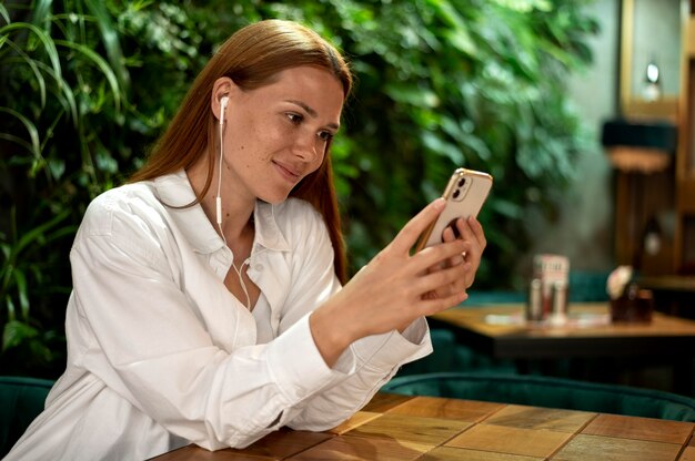 Foto mulher caucasiana mandando mensagem de texto para alguém em seu smartphone