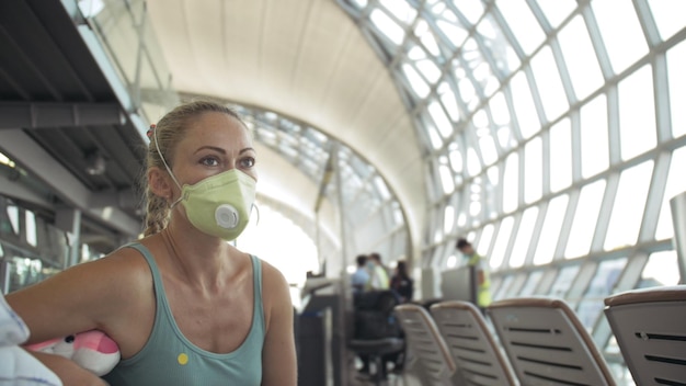 Mulher caucasiana no aeroporto com máscara médica protetora na cabeça contra o fundo do avião Coronavirus sarscov2 covid19