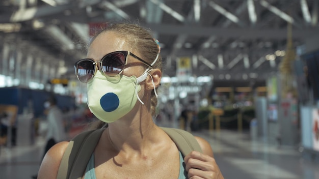 Mulher caucasiana no aeroporto de Suvarnabhumi com máscara médica protetora na cabeça contra o fundo do avião Conceito proteção contra vírus de saúde epidemia de coronavírus sarscov2 covid19 2019ncov