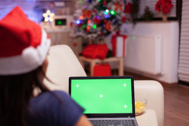 Foto mulher caucasiana olhando para um laptop de chroma key de tela verde com tela isolada