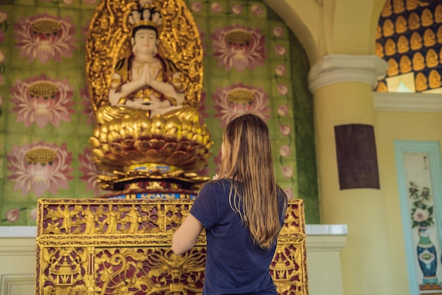 Mulher caucasiana orando em templo budista