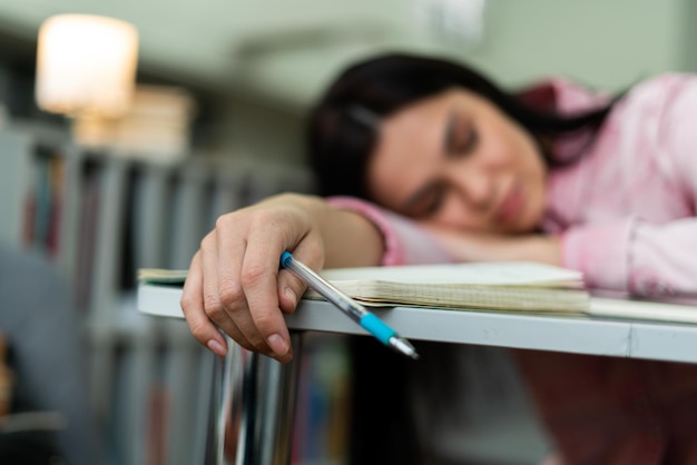 Mulher caucasiana se cansou de trabalhar e estudar ao lado da pilha de papéis e livros Conceito de trabalho e estudo