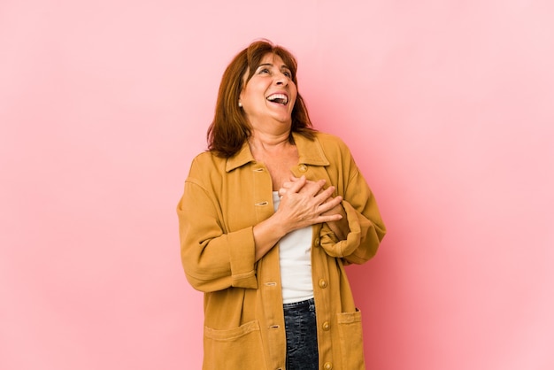 Mulher caucasiana sênior isolada rindo mantendo as mãos no coração, o conceito de felicidade.