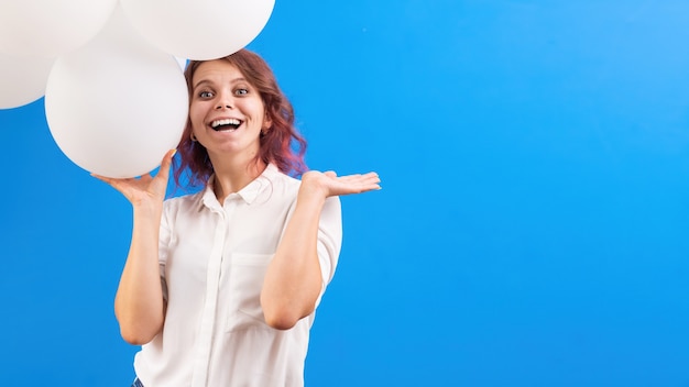 Mulher caucasiana sorridente e feliz com balões brancos