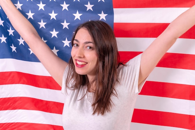 Mulher caucasiana sorrindo com a bandeira dos eua isolada em um closeup de fundo branco