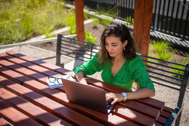 Mulher caucasiana trabalhando com laptop fora do escritório