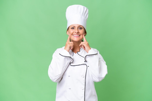 Foto mulher chef de meia idade sobre fundo isolado, sorrindo com uma expressão feliz e agradável
