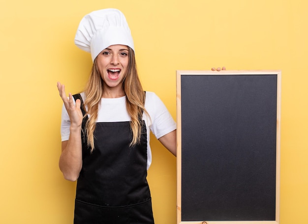 Mulher chef se sentindo feliz e surpresa com algo inacreditável conceito de menu de quadro-negro