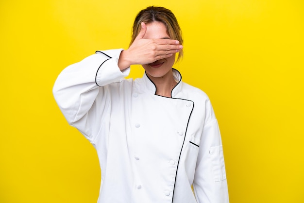 Mulher chef uruguaia isolada em fundo amarelo cobrindo os olhos com as mãos Não quero ver algo