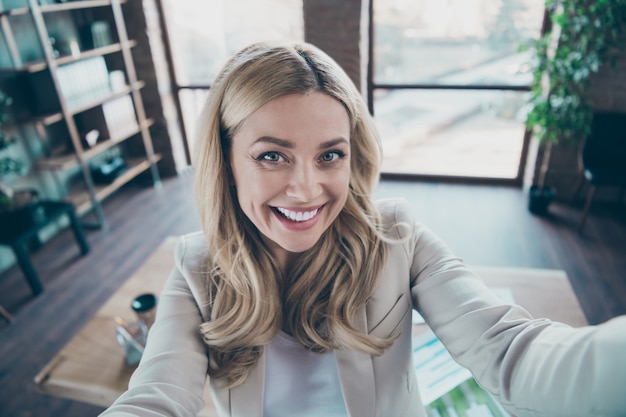 Foto mulher chefe de negócios tira uma selfie com um sorriso radiante