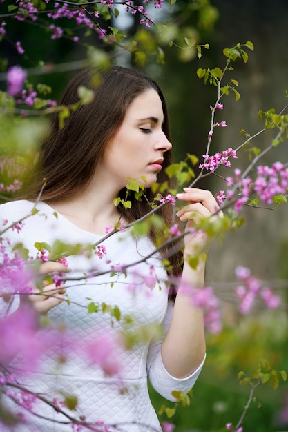 Mulher cheirando as flores na árvore