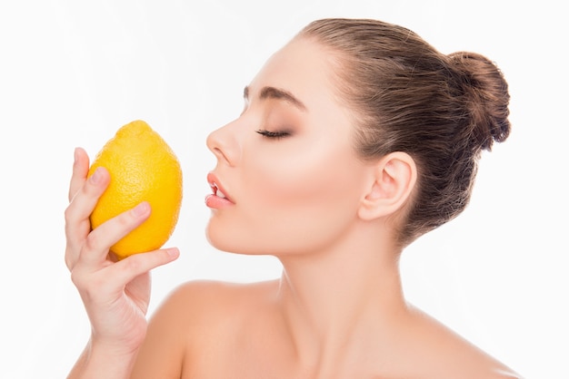 mulher cheirando limão com olhos fechados