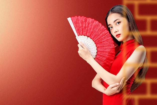 Mulher chinesa asiática em um vestido cheongsam segurando fã celebra o ano novo chinês. Feliz Ano Novo Chinês