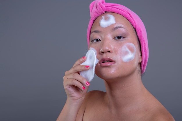 Mulher chinesa bonita e jovem no conceito de beleza de fundo isolado.