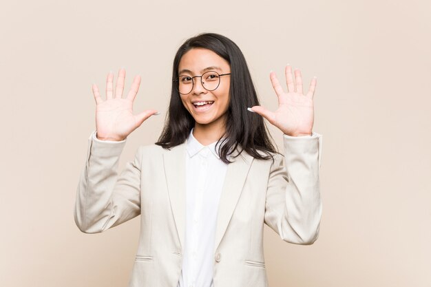 Mulher chinesa de negócios jovem mostrando o número dez com as mãos.