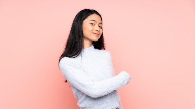 Mulher chinesa em blusa branca isolada em rosa