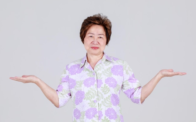 Mulher chinesa idosa engraçada agindo surpreendentemente levantando a mão e cerrando o punho gritando em voz alta como emocionante para um jogo maravilhoso e aproveite para animar a competição como torcedor sênior.