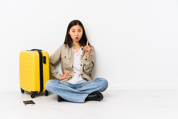 Mulher chinesa nova do viajante que senta guardando um cartão de embarque que tem uma ideia, conceito da inspiração.