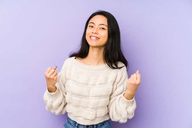 Mulher chinesa nova isolada em uma parede roxa que cheering despreocupada e entusiasmada. conceito de vitória