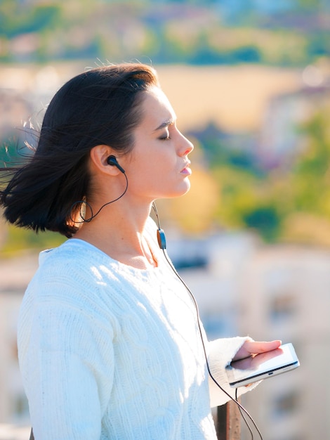 Mulher cidade e fones de ouvido com tablet podcast ou música para ouvir ou relaxar enquanto pensa Trabalhador tecnologia e saúde mental com audição mindfulness e mídia para bem-estar e ideias ou zen