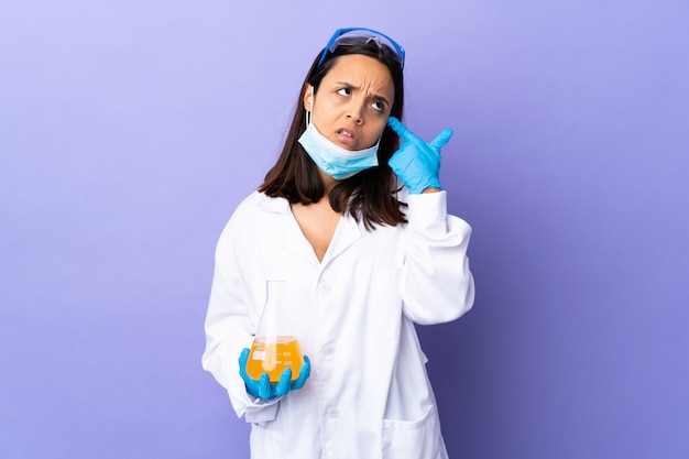 Mulher cientista investigando uma vacina para curar doenças, fazendo o gesto de loucura, colocando o dedo na cabeça