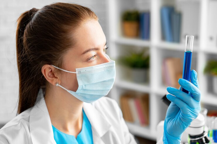 Foto mulher cientista ou trabalhadora de laboratório segurando um frasco de vidro com líquido químico em laboratório