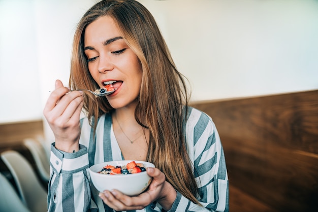 Mulher, cima, comer, aveia, e, frutas, tigela, pequeno almoço