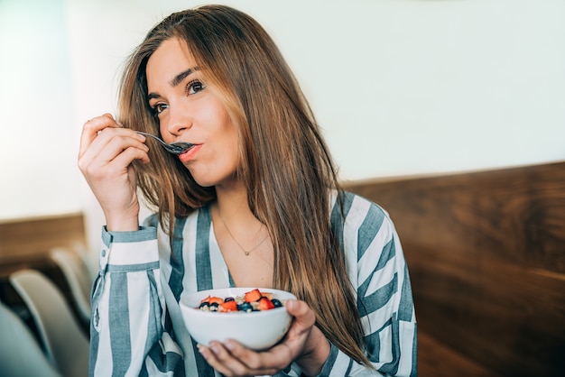 Mulher, cima, comer, aveia, e, frutas, tigela, pequeno almoço