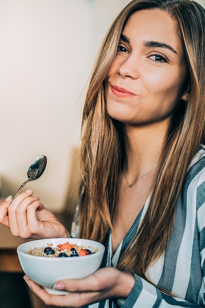 Mulher, cima, comer, aveia, e, frutas, tigela, pequeno almoço