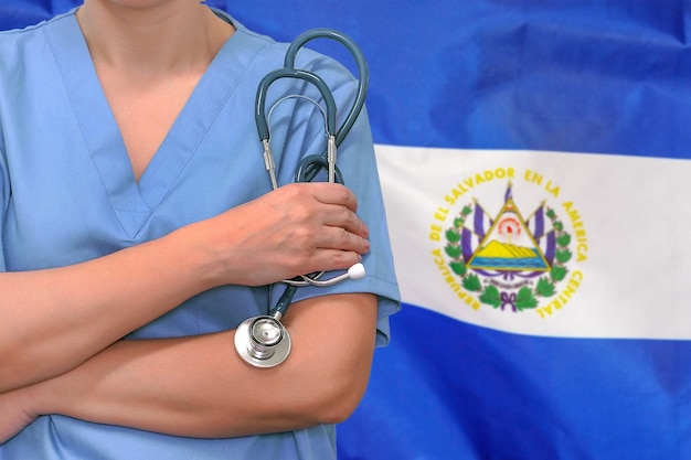 Mulher cirurgiã ou médica com estetoscópio no fundo da bandeira de El Salvador