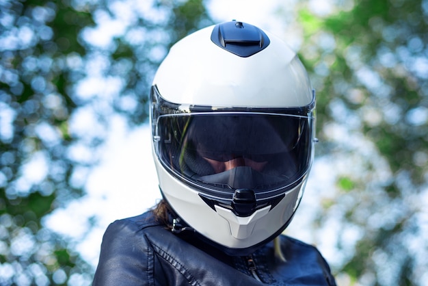 Mulher coloca capacete de moto e fecha o fecho