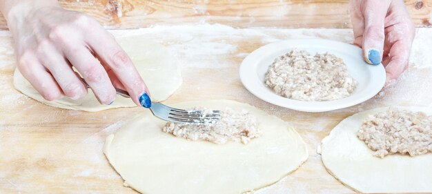 Mulher coloca coberturas na massa para a preparação de tortas